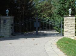 Custom Gate design with Camera, keypad and stone pillars using a black steel gate