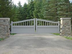 Stone pillars and gray wooden gate with camera and intercom